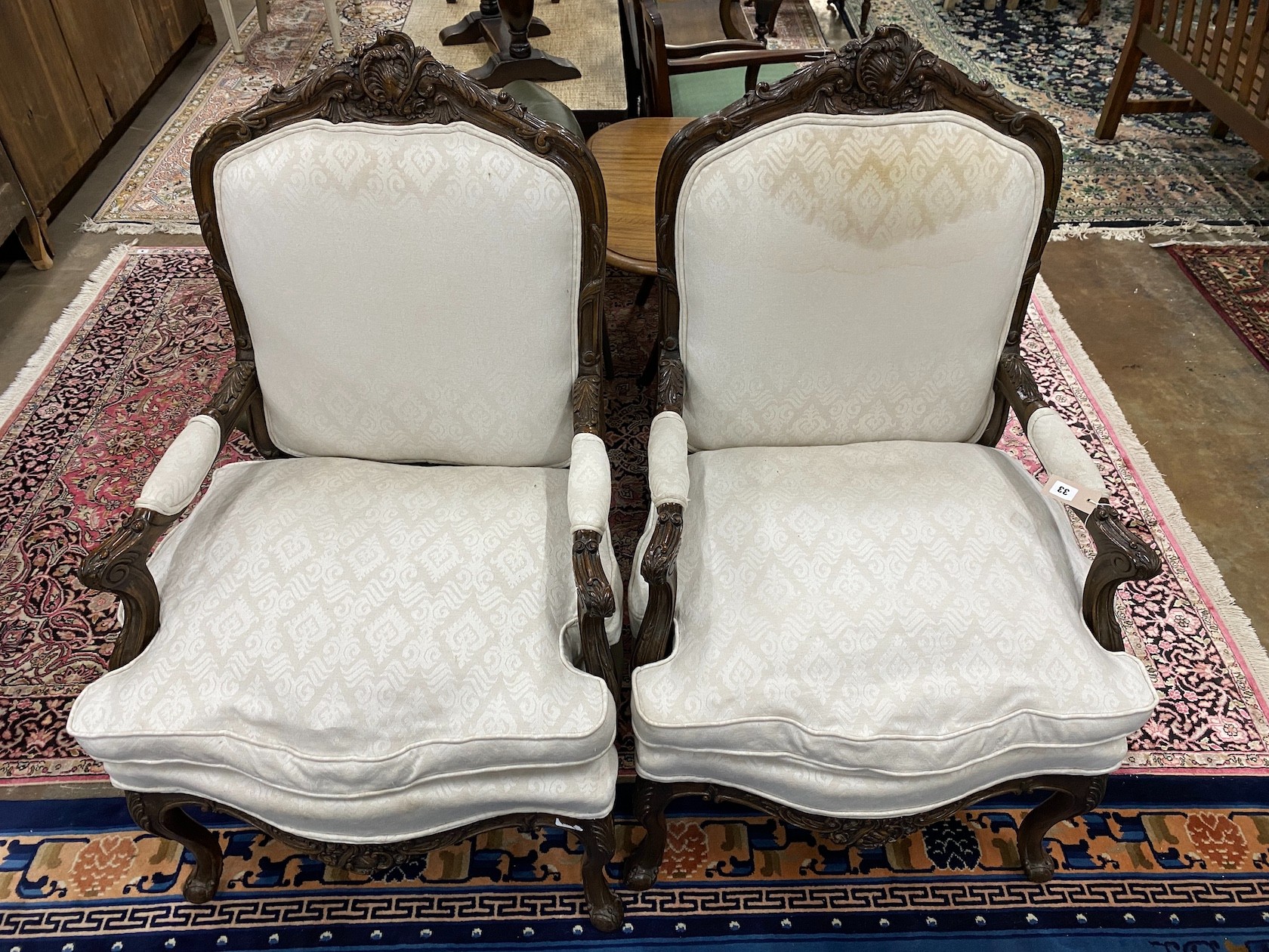 A pair of Louis XVI style carved walnut armchairs, width 67cm, height 113cm